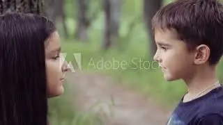 Portrait. A little boy is kissing with a little girl and hugging loving hard each other. Slow motion
