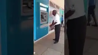A Man talking to an ATM machine to release his money