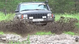 A Jeep Cherokee and a UAZ Patriot rescue a Niva stuck in the mud.