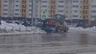 Чувак в ковше погрузчика переправляет людей через поток.