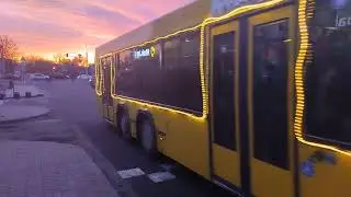 Новогодний автобус по маршруту N 87с на фоне алого неба
