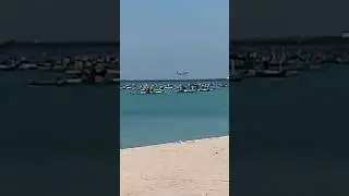 LAGI SANTAI DI PINGGIR PANTAI SAMBIL MELIHAT PESAWAT YANG SEDANG MENDARAT