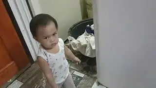 Baby helps mom to put the clothes in the basin