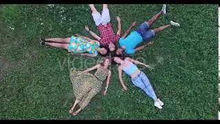 Aerial of group of friends forming a star shape lying in grass | Stock Footage - Envato elements