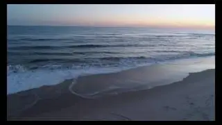 Low aerial tracking shot across and over sand dune to beach and ocean_2