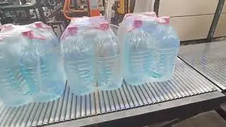Автоматическая групповая упаковка ПЭТ бутылок объемом 5 литров. Упаковочная машина МТУ Вектор 600