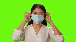 Copyright free green screen video | Young woman putting on a mask on a green background