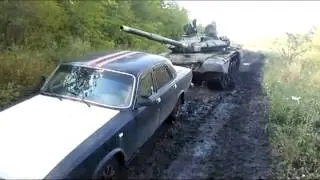 волга вытаскивает танк из грязи