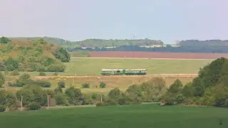 A thunderstorm on the horizon, green fields and a locomotive appearing in the frame here and there
