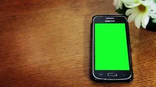 Phone with a green screen on the desk. Video background. Stock footage