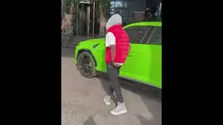 Wizkid lookalike standing next to Wizkid's new Lamborghini. 