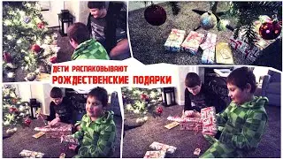 Дети распаковывают рождественские подарки