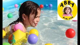 Abby swimming with colorful balls