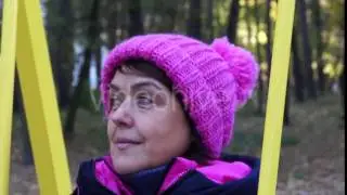 a Beautiful Middle Age Woman Swinging on a Playground in a Park Zone