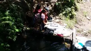 Indigenous Mayan women washing hair and laundry in a stream