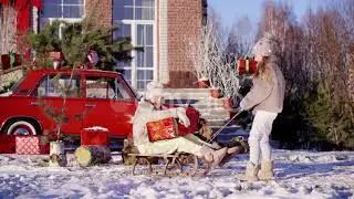 Two Funny Teenage Girls Sledding on Christmas Tree While Holidays. Happy Girlfriends with Christ...