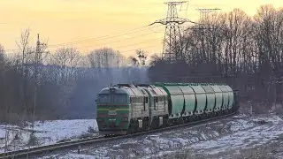 A diesel locomotive with a glowing red eye quietly pulls the train