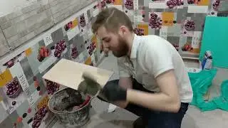 Фартук на кухне Андрей укладывает