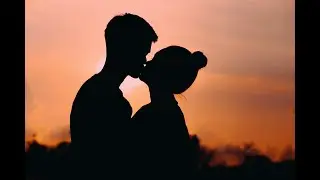 Two Young Couples Are Sitting On The Beach Near The Bonfire
