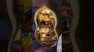 A miniature house crafted within a gourd, a handmade marvel, creates a magical miniature landsc