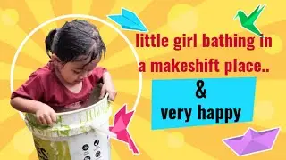 little girl taking a bath with a makeshift place and very happy.. 